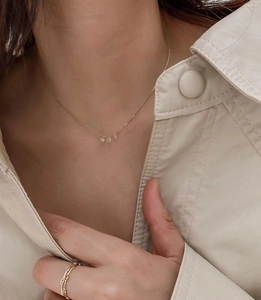 Elegant gold 925 silver necklace with three zircon pendants worn on a stylish model