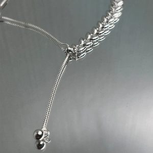 Macro detail of 925 sterling silver wheat chain with adjustable sliding ball clasp