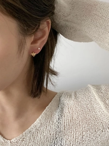 Close-up of elegant 925 sterling silver bow and pearl earrings worn by a model