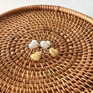 Detailed view of 925 silver woven heart earrings with crystal studs in gold and silver