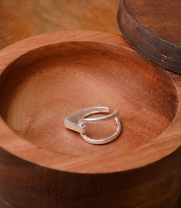 Macro shot of S925 sterling silver minimalist geometric ring inside dark wooden box