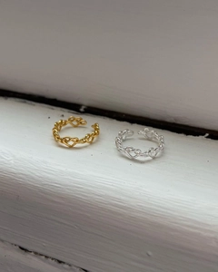 Détail de bagues ouvertes en forme de cœur entrelacé finitions or et argent