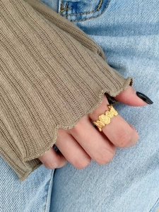 Detailed view of an irregular textured gold ring with a crushed lava aesthetic