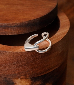 Close-up of S925 sterling silver geometric open ring on a dark wooden jewelry box edge