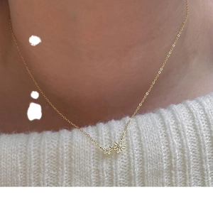 Élégant collier marguerite en argent S925 doré porté avec un pull en maille blanche