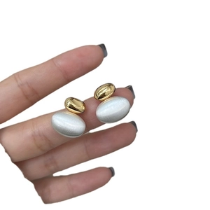 Two-tone oval earrings featuring a gold glossy top and silver matte brushed metal texture