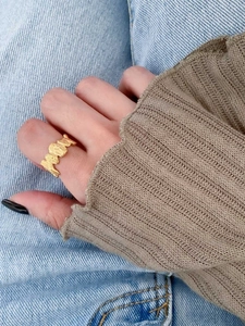 Detailed view of an irregular wrinkled texture gold open ring worn on a finger