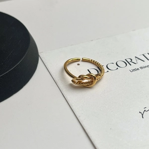 Detailed view of golden knot ring with mixed smooth and spiral textured adjustable band