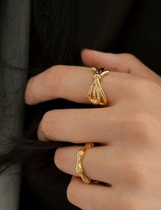 Close-up of elegant gold knot and bamboo style adjustable rings on a model hand