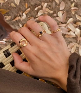 Close-up of a 4-piece gold ring set with irregular cutout and black heart details