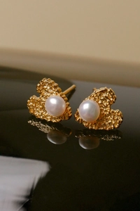 Macro view of gold heart stud earrings with freshwater pearls and hammered texture