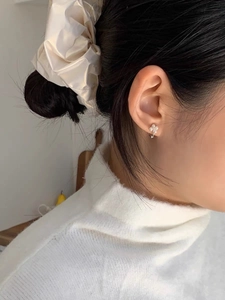 Vue détaillée d'une boucle d'oreille fleur en perles argent S925 et chouchou en soie