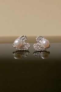 Detailed view of freshwater pearl earrings with textured silver lava metal brackets and reflection