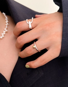 Detail of silver 925 asymmetric geometric rings styled with a navy blue blazer