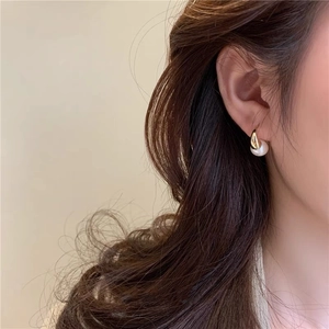 Detailed view of elegant gold drop pearl earrings worn for a minimalist and classy look