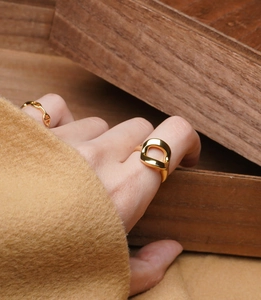 Detailed close-up of golden hollow geometric silver ring with a high polished finish