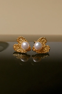 Macro shot of vintage irregular gold heart earrings with shiny white freshwater pearls
