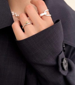 Minimalist 925 sterling silver geometric rings and pearl necklace worn on dark navy jacket