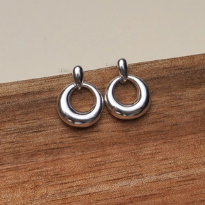 Minimalist 925 sterling silver chunky hoop earrings displayed on a natural wooden stand