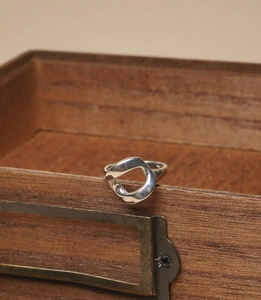 Close-up of minimalist 925 sterling silver hollow geometric ring on a wooden box