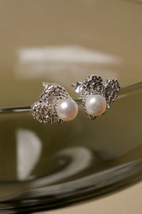 Close-up of S925 silver lava texture heart earring with glossy freshwater pearl inlay