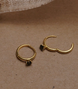 Close-up of 925 sterling silver huggie earrings with black onyx in six-prong setting