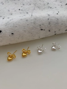 Détails des boucles d'oreilles nœud en forme de cœur avec finitions or et argent polies
