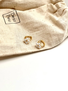 Détail de boucles d'oreilles fleur en argent S925 avec perles et pochon bijoux