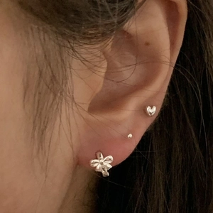 925 sterling silver bow and heart stud earring set displayed on model ear