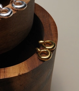 Macro shot of 925 sterling silver donut earrings in polished gold and silver finishes
