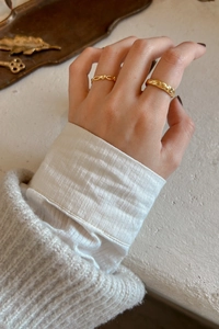 Details goldener Ringe mit Herz-Unendlichkeitssymbol und gedrehtem Flechtmuster-Design