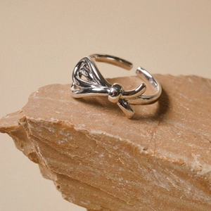Elegant 925 sterling silver bow ring with adjustable opening on natural rock background