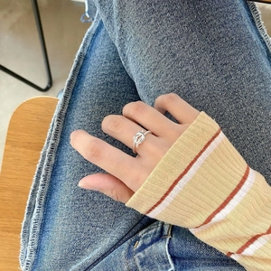 Minimalist sterling silver knot open ring with twisted rope texture worn on a finger