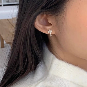 Élégantes boucles d'oreilles fleurs en perles argent 925 portées par une femme