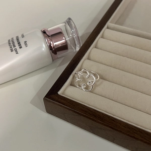 Macro detail of silver floral hollow ring on a velvet jewelry box with soft lighting