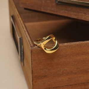 Minimalist irregular hollow geometric open ring in gold finish on wooden display