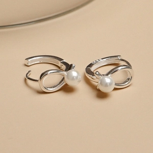925 silver bow pearl hoop earrings with minimalist design on beige background