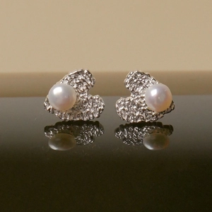 Elegant freshwater pearl stud earrings with irregular silver hammered metal base design