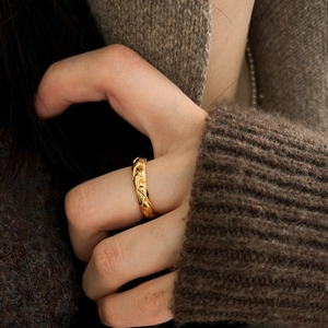 Minimalistischer 925 Silberring Goldfarben mit Weizenmuster auf braunem Strickpullover