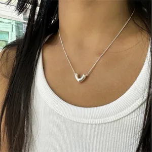 Close-up of a minimalist 925 sterling silver V-shaped necklace on a model neck