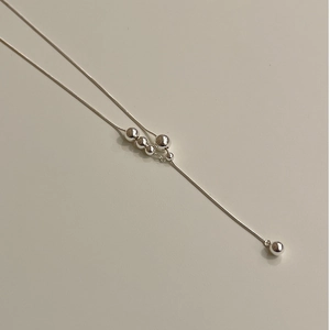 Sleek silver snake chain necklace with gradient metallic beads in a minimalist style