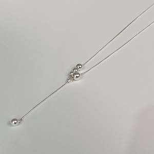 Minimalist silver snake chain necklace with gradient beads on a clean white background