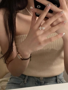 Close-up of dual heart 925 silver ring worn by model in a warm cozy setting