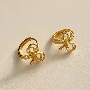 Détail macro des boucles d'oreilles papillon en argent S925 doré avec fini poli