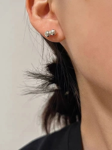 Close-up of minimalist 925 silver double bean earrings on ear with high-gloss finish