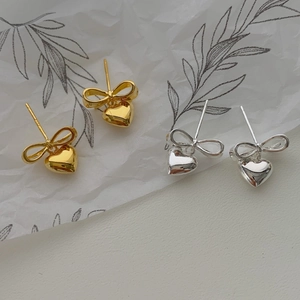 Boucles d'oreilles nœud et cœur en argent et or avec une finition miroir polie élégante