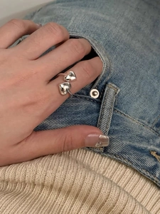 Close-up of 925 sterling silver open ring with double heart design worn on finger