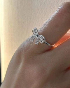 Detailed macro shot of 925 sterling silver hollow bow ring with woven texture on finger