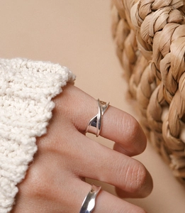 Detailed close-up of a 925 sterling silver ring featuring a modern twisted folded design