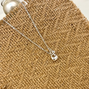 Minimalist S925 sterling silver necklace with smooth organic bean pendant on burlap background
